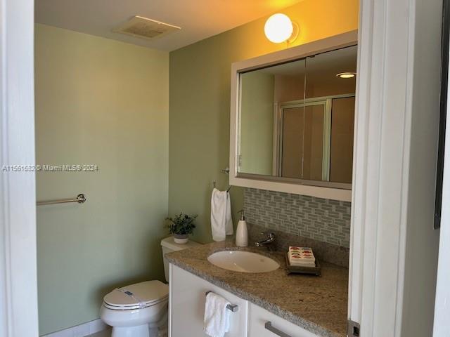 185 Southwest 7th Street, Unit 1403 Miami, FL 33130 - Photo 15 of 31 a bathroom with a granite countertop sink and a toilet
