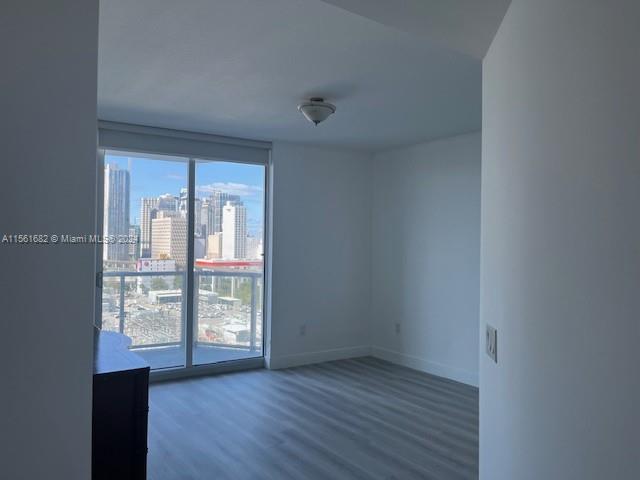 185 Southwest 7th Street, Unit 1403 Miami, FL 33130 - Photo 6 of 31 wooden floor in an empty room with a window