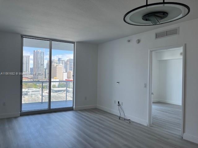 185 Southwest 7th Street, Unit 1403 Miami, FL 33130 - Photo 7 of 31 an empty room with wooden floor and windows
