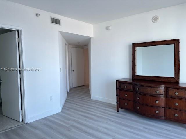 185 Southwest 7th Street, Unit 1403 Miami, FL 33130 - Photo 8 of 31 a room with a dresser and a mirror