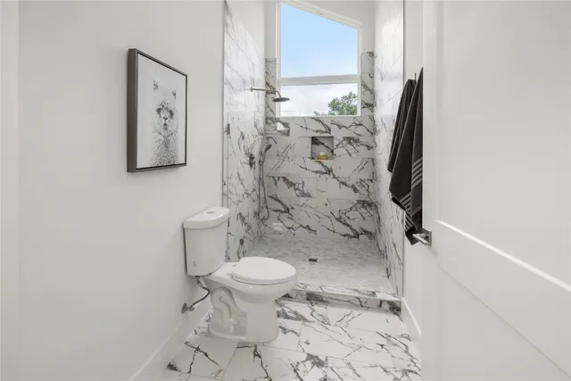 a bathroom with a toilet a sink a mirror and vanity