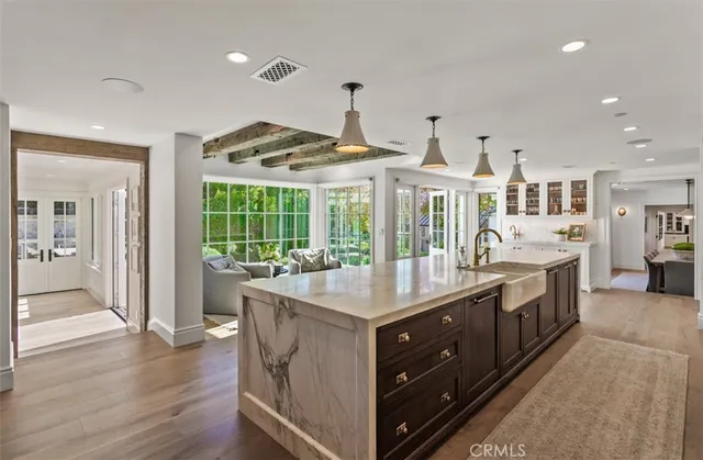 a large white kitchen with a large window and stainless steel appliances