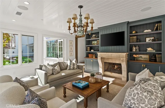a living room with furniture a flat screen tv and a fireplace