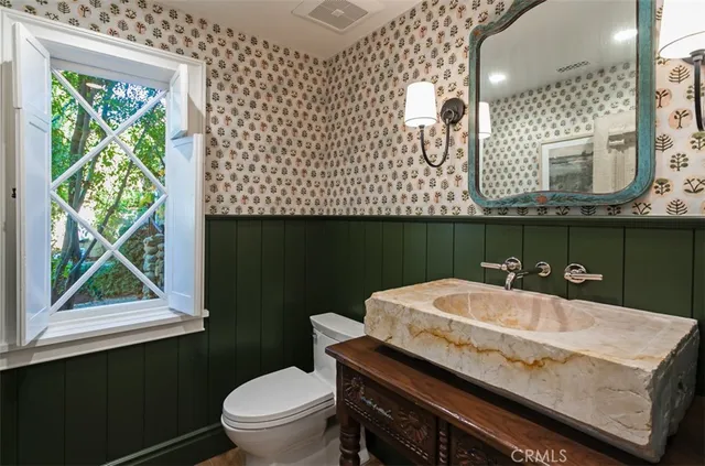 a bathroom with a sink a toilet and a window