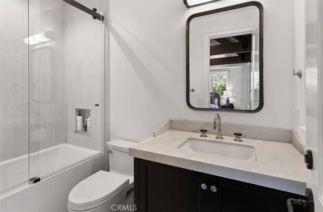 a bathroom with a toilet a sink a tub and mirror