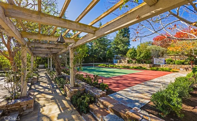 a view of a tennis ground with large trees