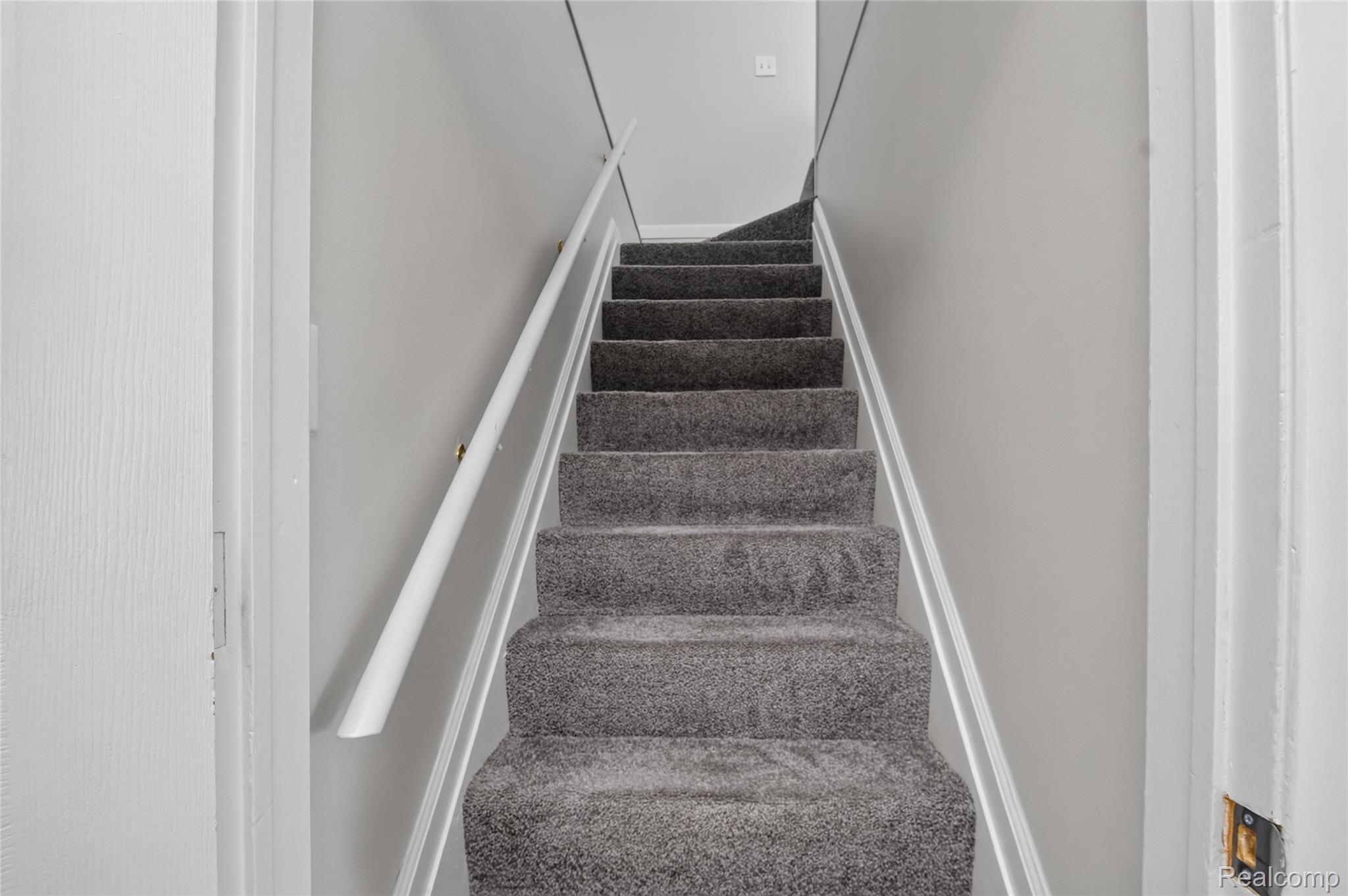12972 Callender Street Southgate, MI 48195 - Photo 25 of 40 Carpeted staircase featuring grey pile carpeting, white painted handrails, and light grey wall finishes