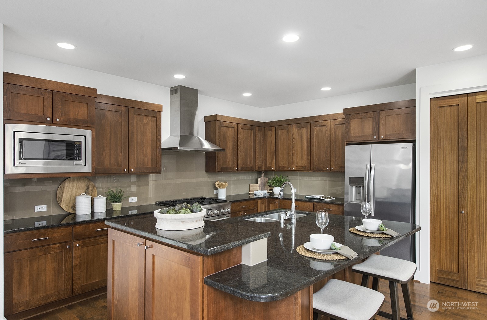 1229 North 42nd Place Renton, WA 98056 - Photo 16 of 40 a kitchen with a refrigerator a sink a stove a dining table and chairs