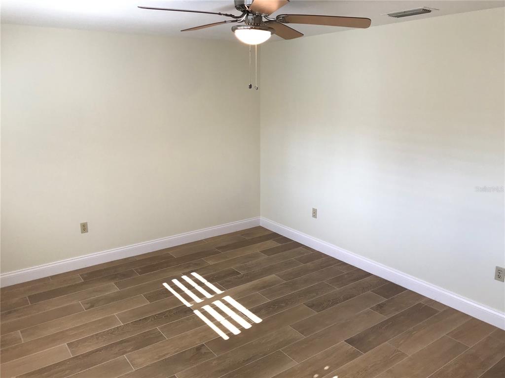 7806 17th Avenue Northwest Bradenton, FL 34209 - Photo 16 of 33 a view of wooden floor and a chandelier fan in a room