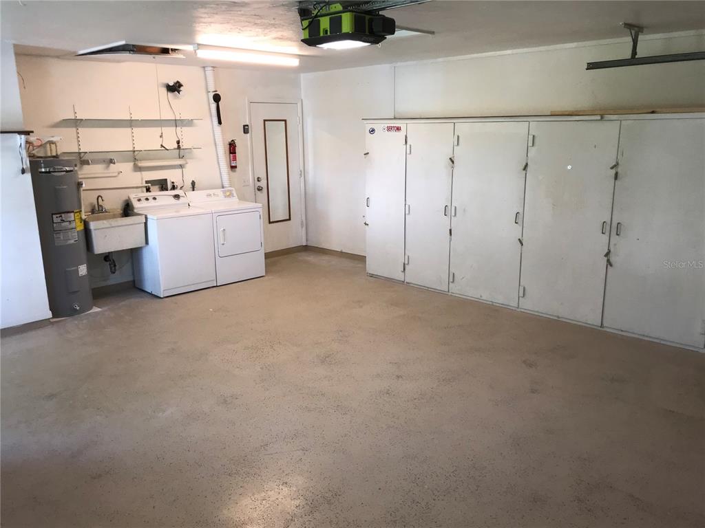 7806 17th Avenue Northwest Bradenton, FL 34209 - Photo 23 of 33 a view of a kitchen with refrigerator and white cabinets