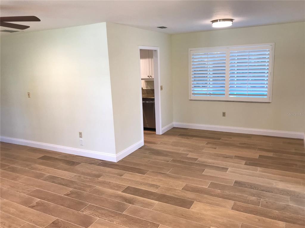 7806 17th Avenue Northwest Bradenton, FL 34209 - Photo 9 of 33 a view of an empty room with wooden floor and a window