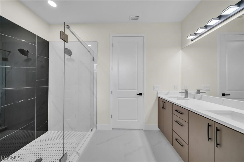 4306 2nd Street Southwest Lehigh Acres, FL 33976 - Photo 12 of 21 a spacious bathroom with a double vanity sink a large mirror and shower