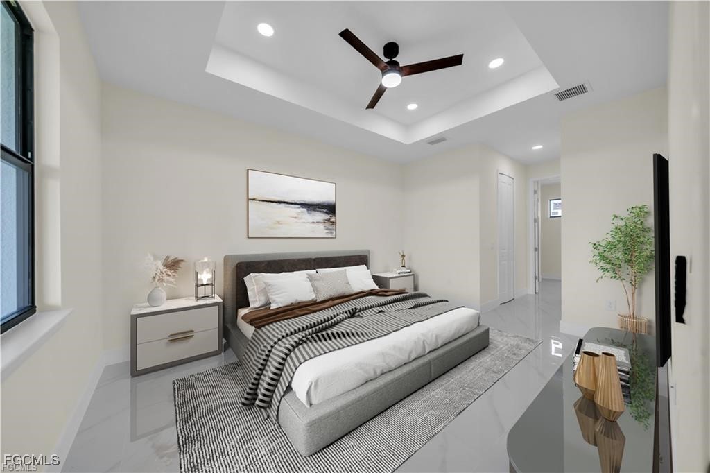 4306 2nd Street Southwest Lehigh Acres, FL 33976 - Photo 15 of 21 a bedroom with a large bed and a chandelier