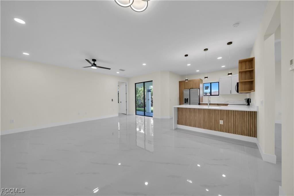 4306 2nd Street Southwest Lehigh Acres, FL 33976 - Photo 3 of 21 a large kitchen with stainless steel appliances a large counter top a stove and a sink