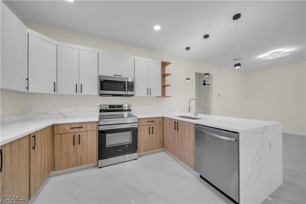 4306 2nd Street Southwest Lehigh Acres, FL 33976 - Photo 7 of 21 a kitchen with cabinets stainless steel appliances and a sink