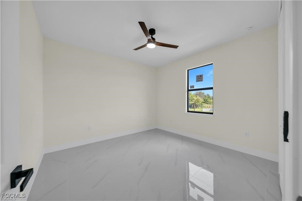 4306 2nd Street Southwest Lehigh Acres, FL 33976 - Photo 10 of 21 a view of an empty room with a ceiling fan