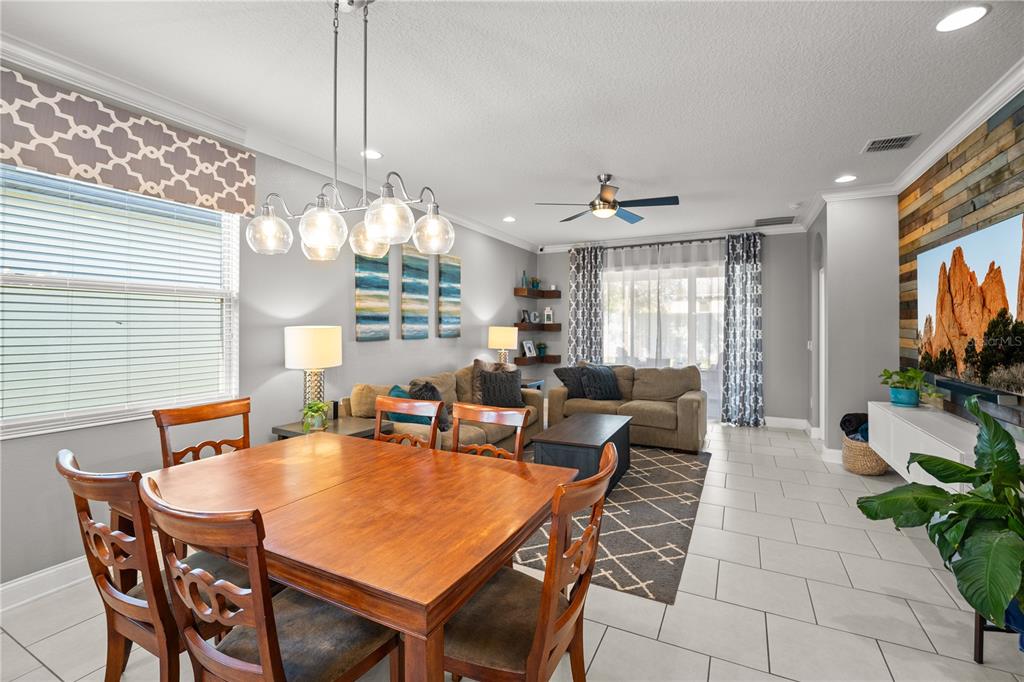 5196 Appenine Loop East St. Cloud, FL 34771 - Photo 11 of 39 a dining room with furniture a chandelier and window