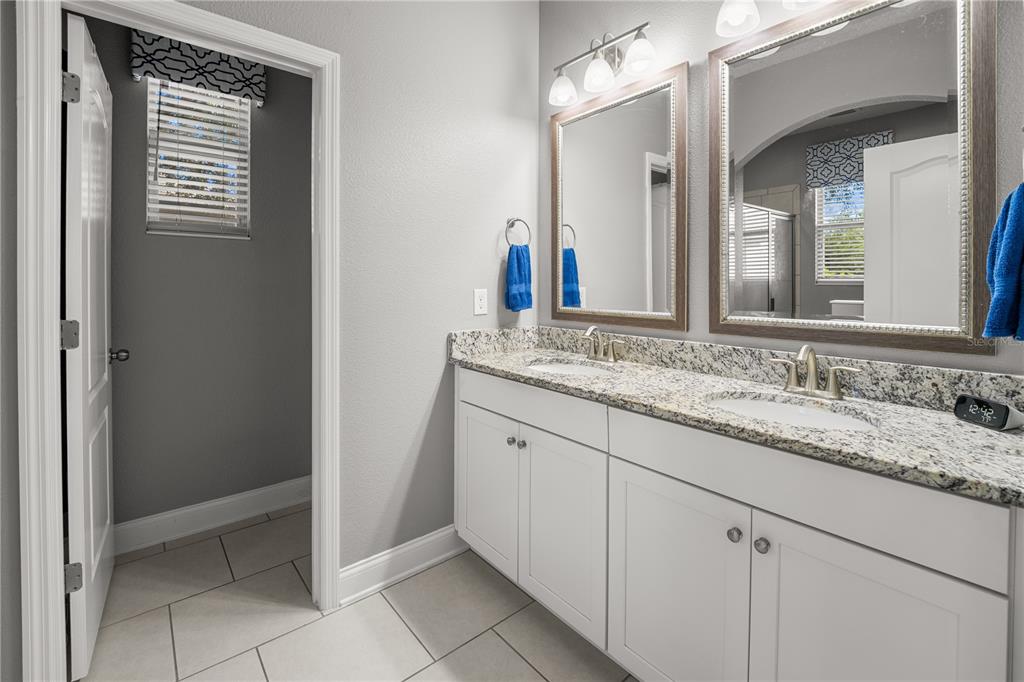 5196 Appenine Loop East St. Cloud, FL 34771 - Photo 17 of 39 a bathroom with a granite countertop sink and a mirror