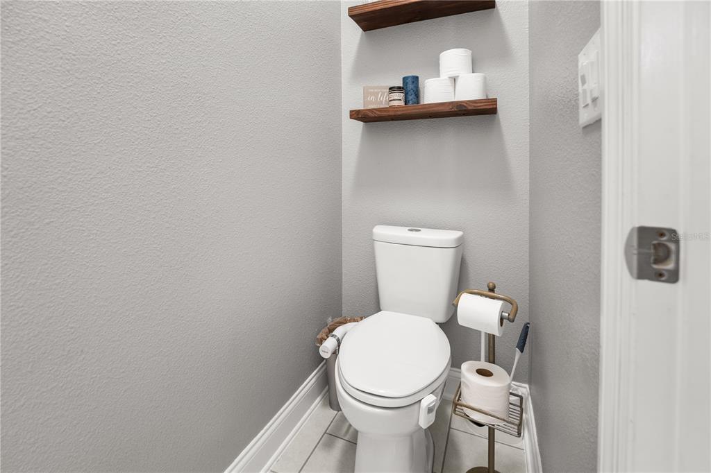 5196 Appenine Loop East St. Cloud, FL 34771 - Photo 19 of 39 a white toilet sitting next to a white sink and vanity