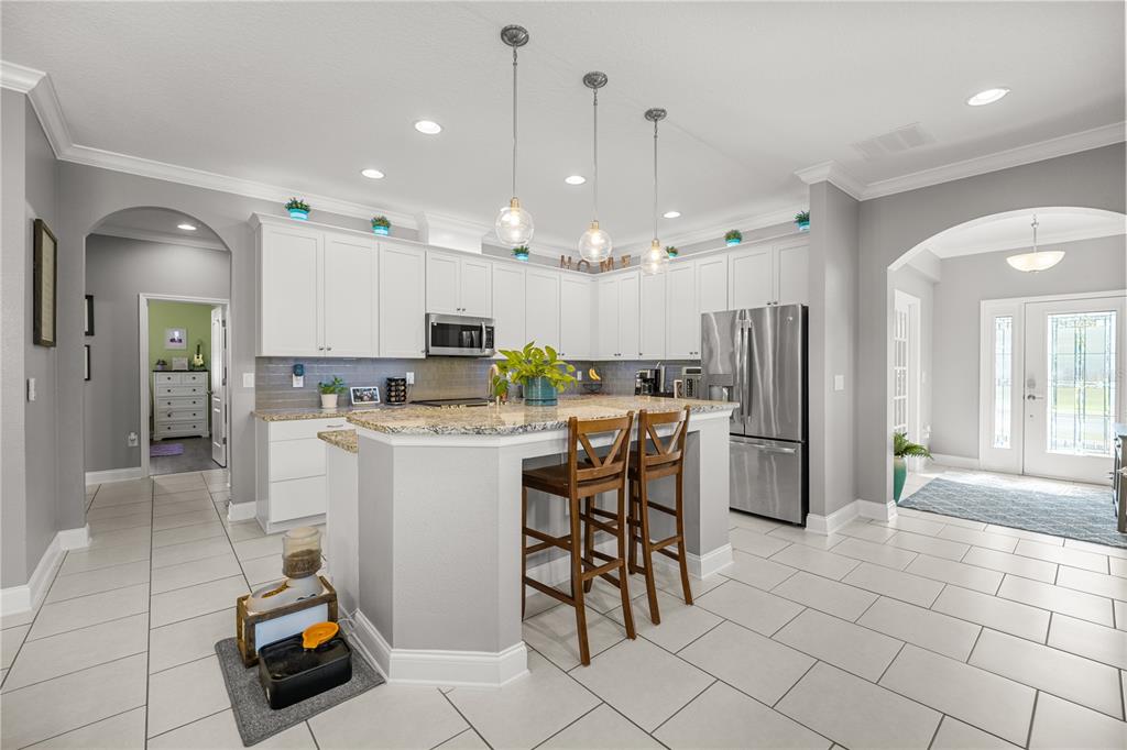 5196 Appenine Loop East St. Cloud, FL 34771 - Photo 5 of 39 a kitchen with a sink a refrigerator and chairs