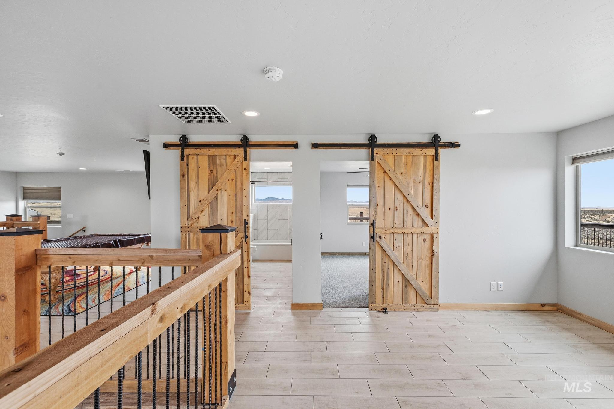 870 Desert Wind Road Boise, ID 83716 - Photo 31 of 50 Spacious room featuring light-toned tile flooring, recessed lighting, and a barn door entry