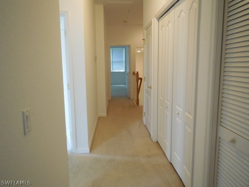 4381 Lazio Way, Unit 501 Fort Myers, FL 33901 - Photo 16 of 25 a view of a hallway with a wooden door