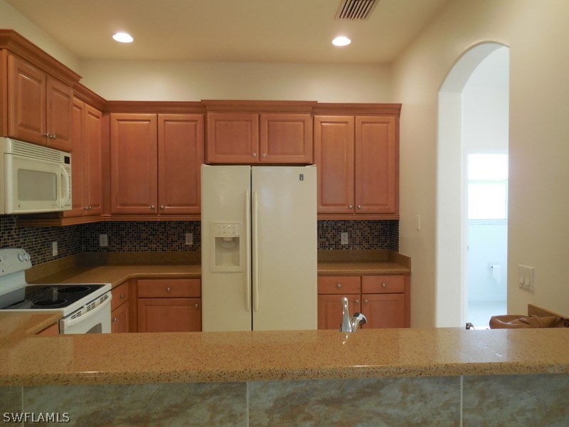 4381 Lazio Way, Unit 501 Fort Myers, FL 33901 - Photo 6 of 25 a kitchen with a refrigerator sink and cabinets