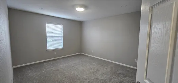 an empty room with windows and entrance to other room