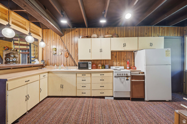 8505 South Snake Crk Road Salt Lake City, UT 84121 - Photo 21 of 67 Kitchen area featuring wood-paneled walls and exposed ceiling beams