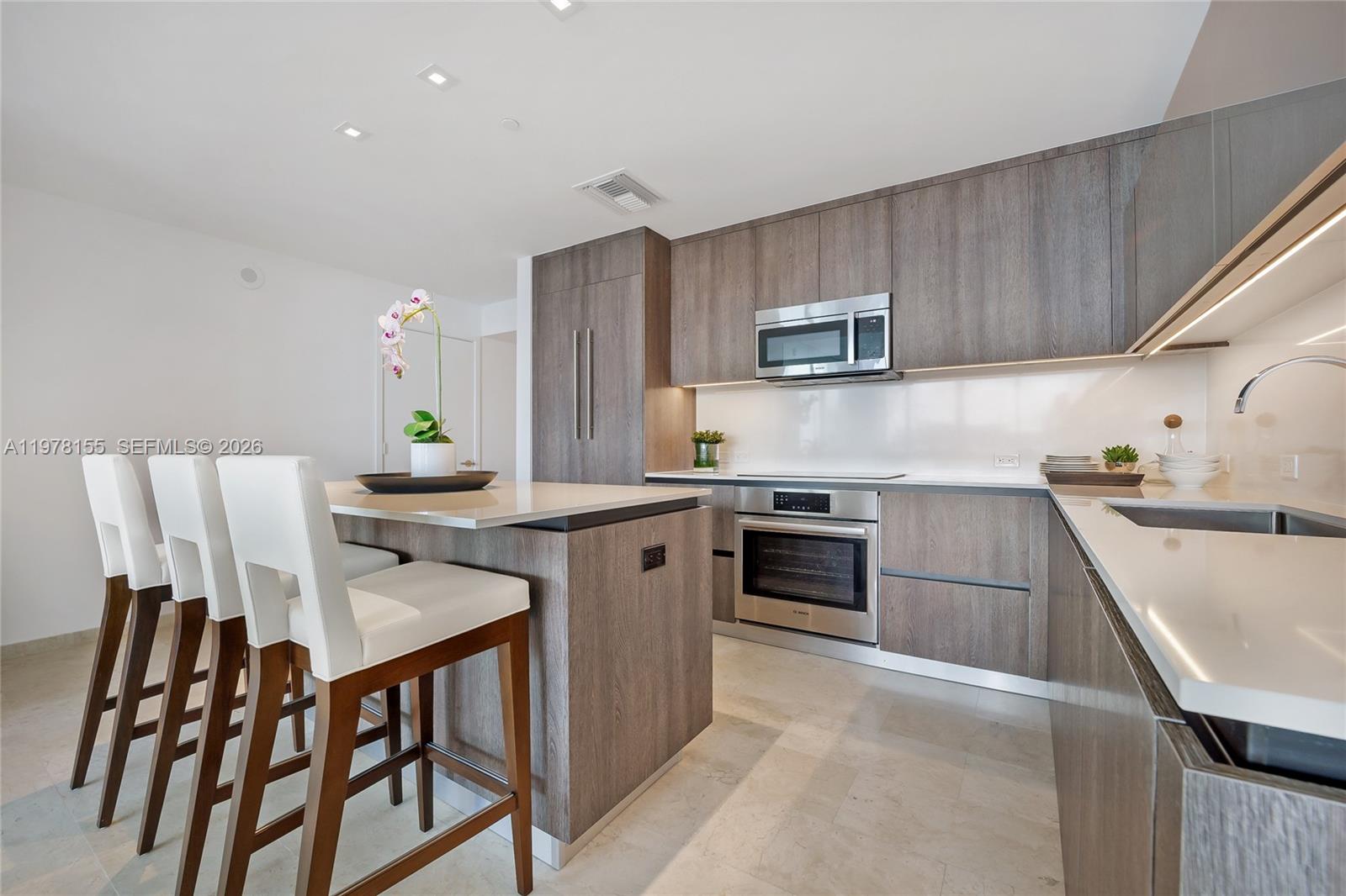 88 Southwest 7th Street, Unit 1810 Miami, FL 33130 - Photo 4 of 13 a kitchen with stainless steel appliances granite countertop a stove a sink dishwasher and a refrigerator