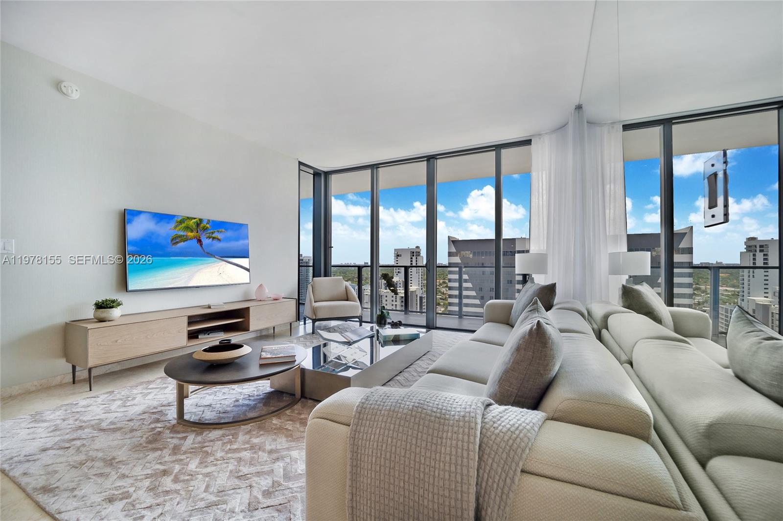 88 Southwest 7th Street, Unit 1810 Miami, FL 33130 - Photo 5 of 13 a living room with furniture a flat screen tv and a floor to ceiling window