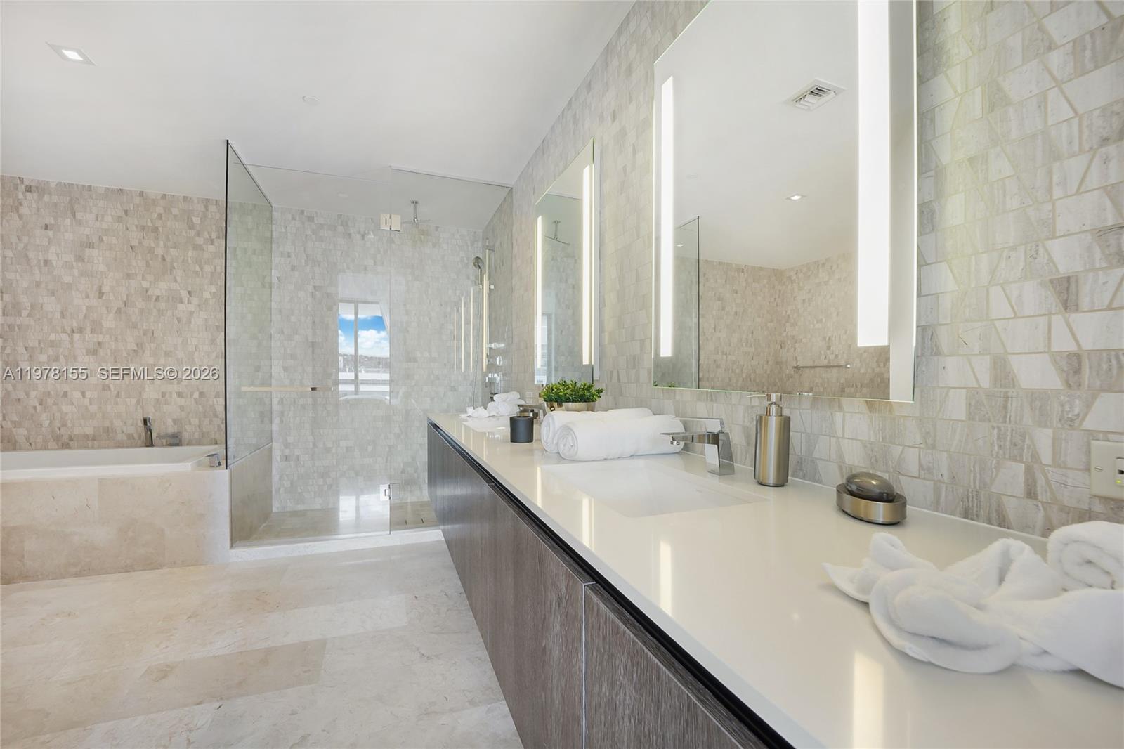 88 Southwest 7th Street, Unit 1810 Miami, FL 33130 - Photo 8 of 13 a bathroom with a double vanity sink window and a bathtub