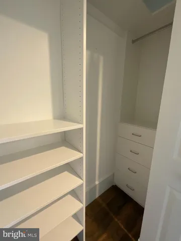 a view of walk in closet with empty racks
