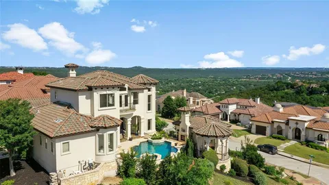 an aerial view of residential houses with outdoor space and ocean view