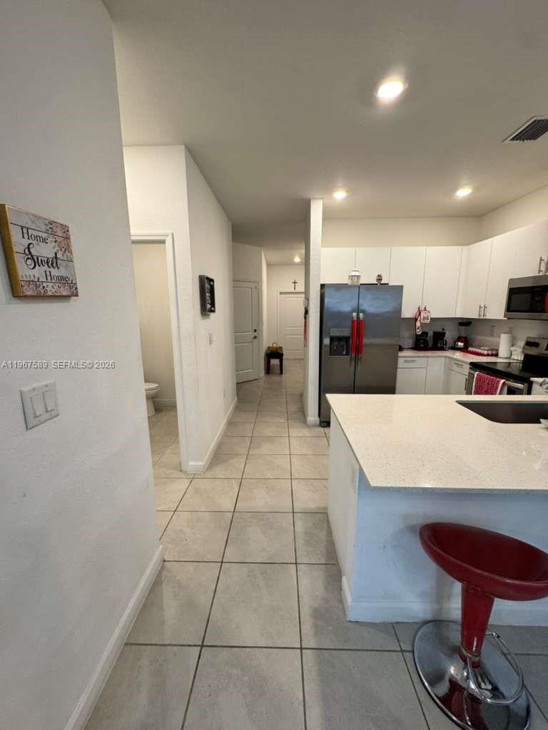 13043 Southwest 286th Street Homestead, FL 33033 - Photo 12 of 34 a large kitchen with a large counter top space a sink stainless steel appliances and cabinets