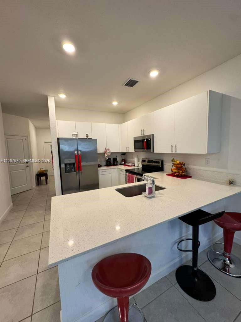 13043 Southwest 286th Street Homestead, FL 33033 - Photo 13 of 34 a kitchen with stainless steel appliances kitchen island granite countertop a sink a refrigerator and a stove
