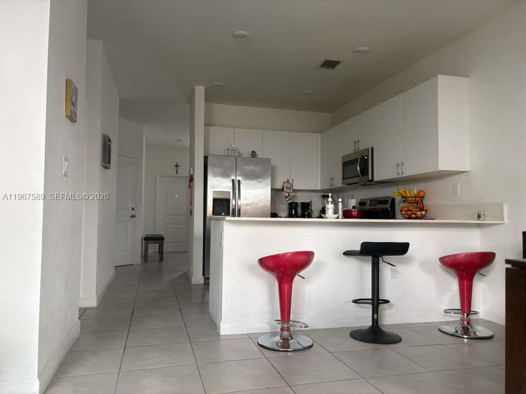 13043 Southwest 286th Street Homestead, FL 33033 - Photo 14 of 34 a kitchen with stainless steel appliances kitchen island granite countertop a refrigerator and a stove