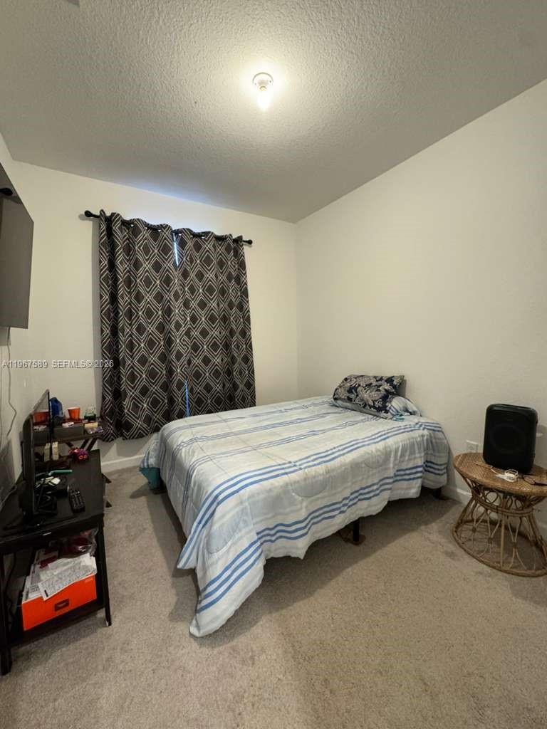 13043 Southwest 286th Street Homestead, FL 33033 - Photo 23 of 34 a bedroom with a bed and a chair