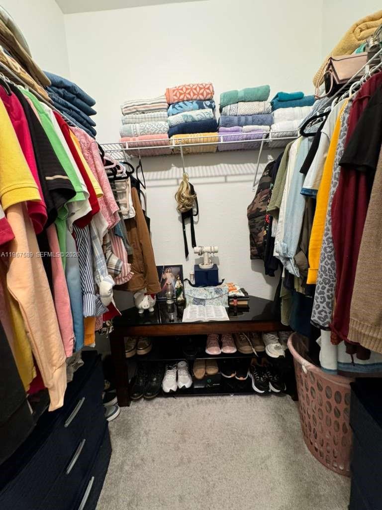 13043 Southwest 286th Street Homestead, FL 33033 - Photo 25 of 34 a view of walk in closet with clothes and shoes
