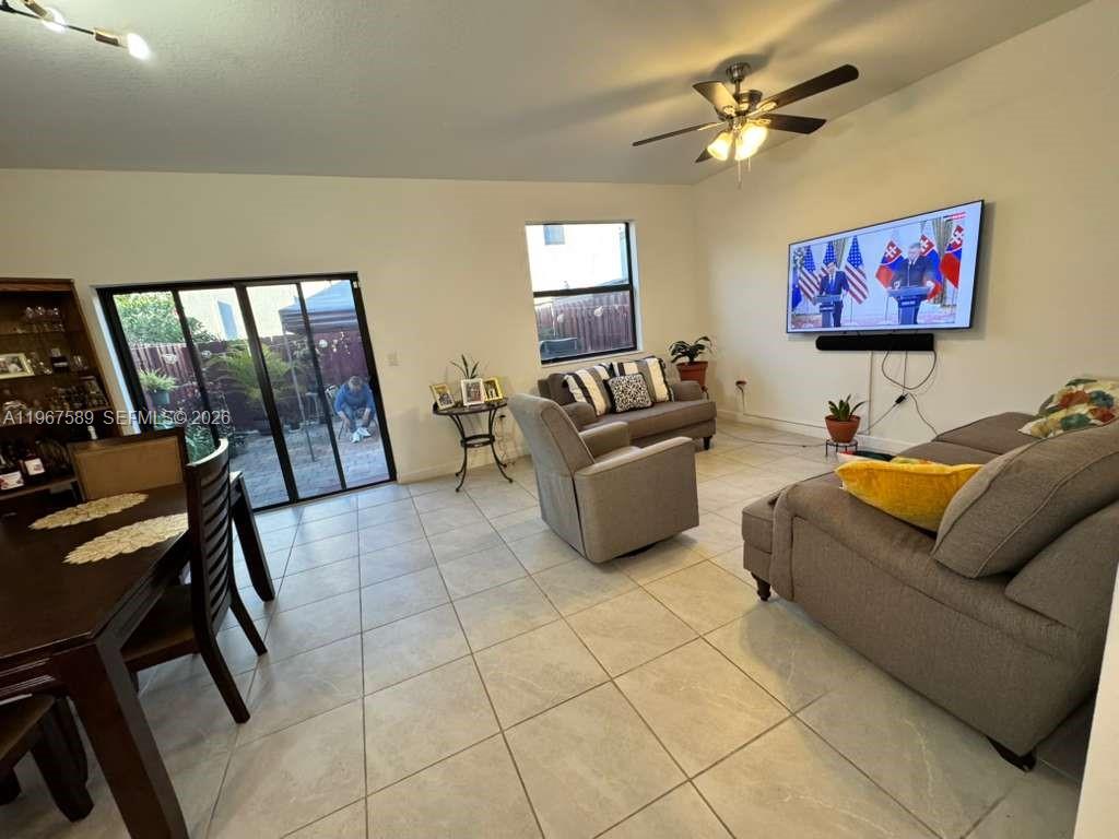 13043 Southwest 286th Street Homestead, FL 33033 - Photo 8 of 34 a living room with couches a coffee table and a flat screen tv with kitchen view