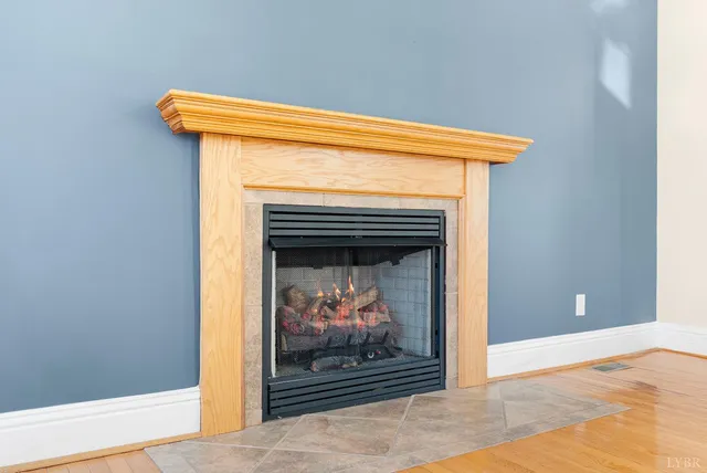 a view of a livingroom with wooden floor and a fireplace
