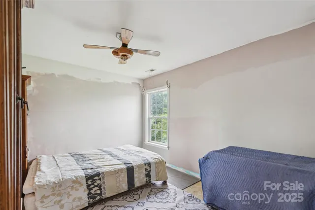 a bedroom with a bed a dresser and a window