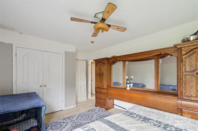 a room with chandelier fan and wooden floor