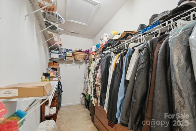 a view of walk in closet with clothes and shoes