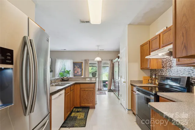 a kitchen with stainless steel appliances a refrigerator sink and stove