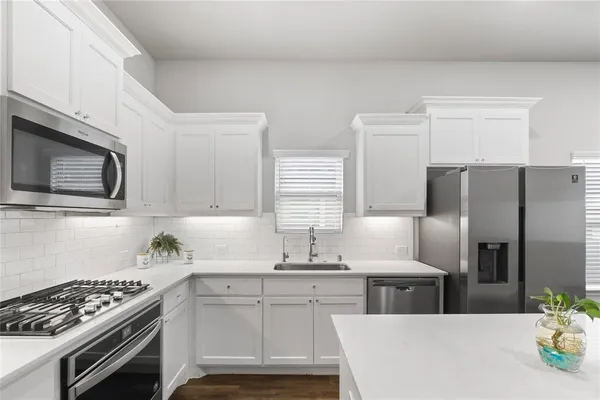 a kitchen with stainless steel appliances granite countertop a sink stove and refrigerator