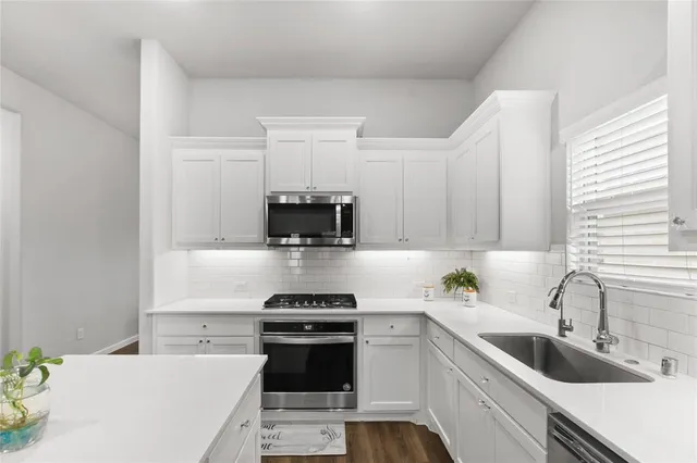 a kitchen with a sink a stove and cabinets