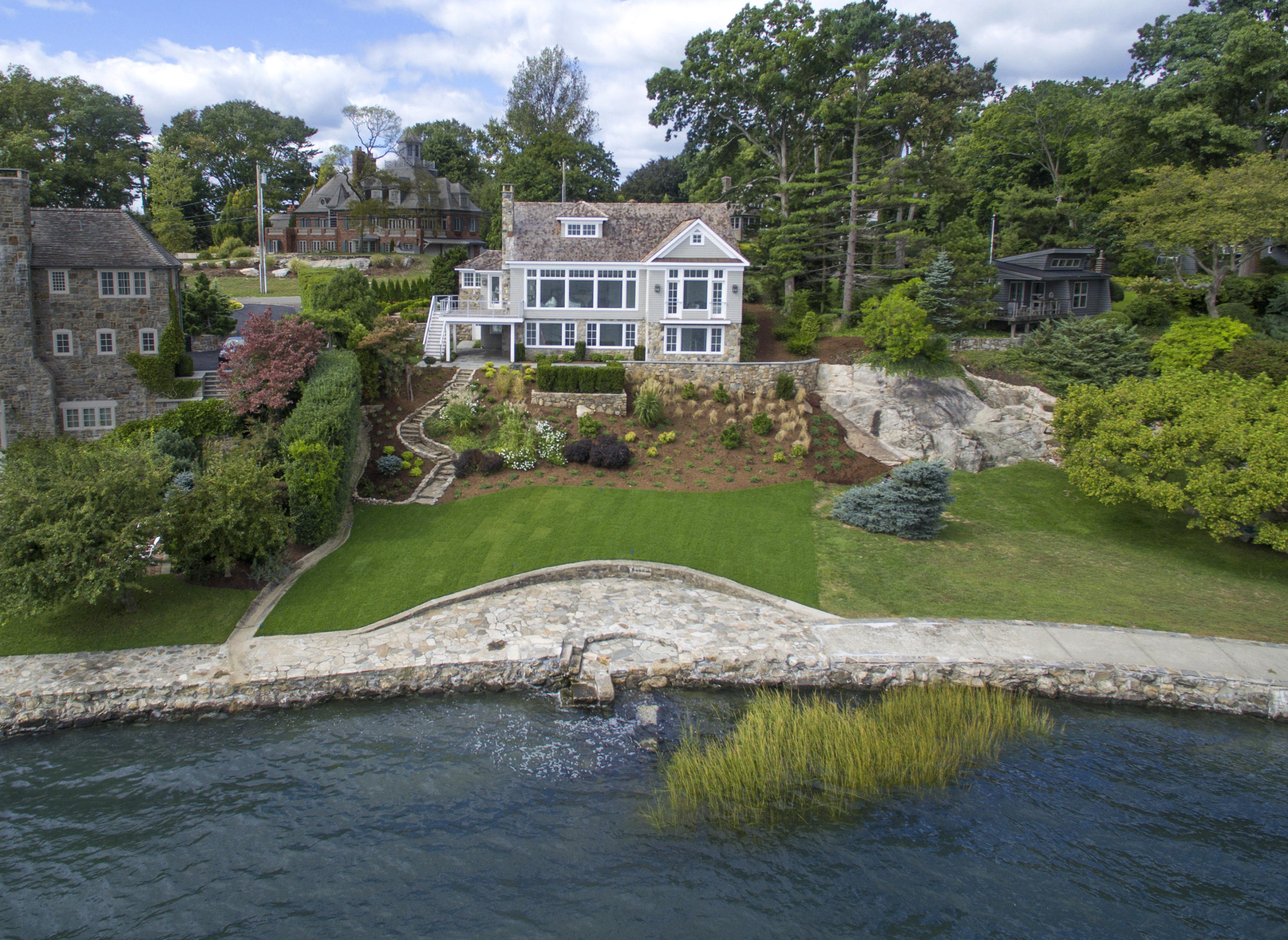 an aerial view of a house with a garden and lake view