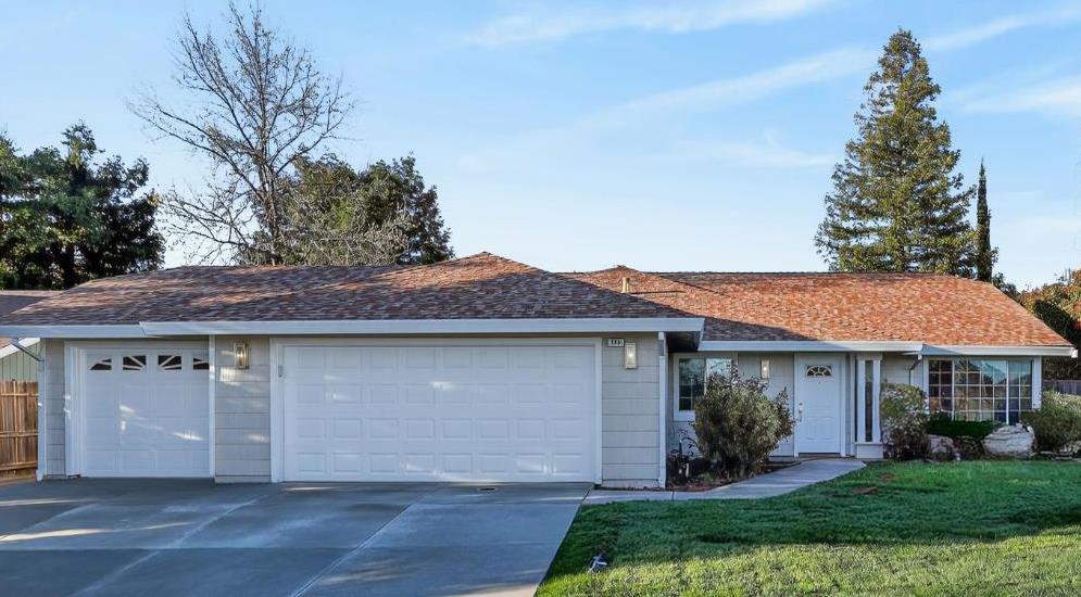 a front view of a house with a garden and yard
