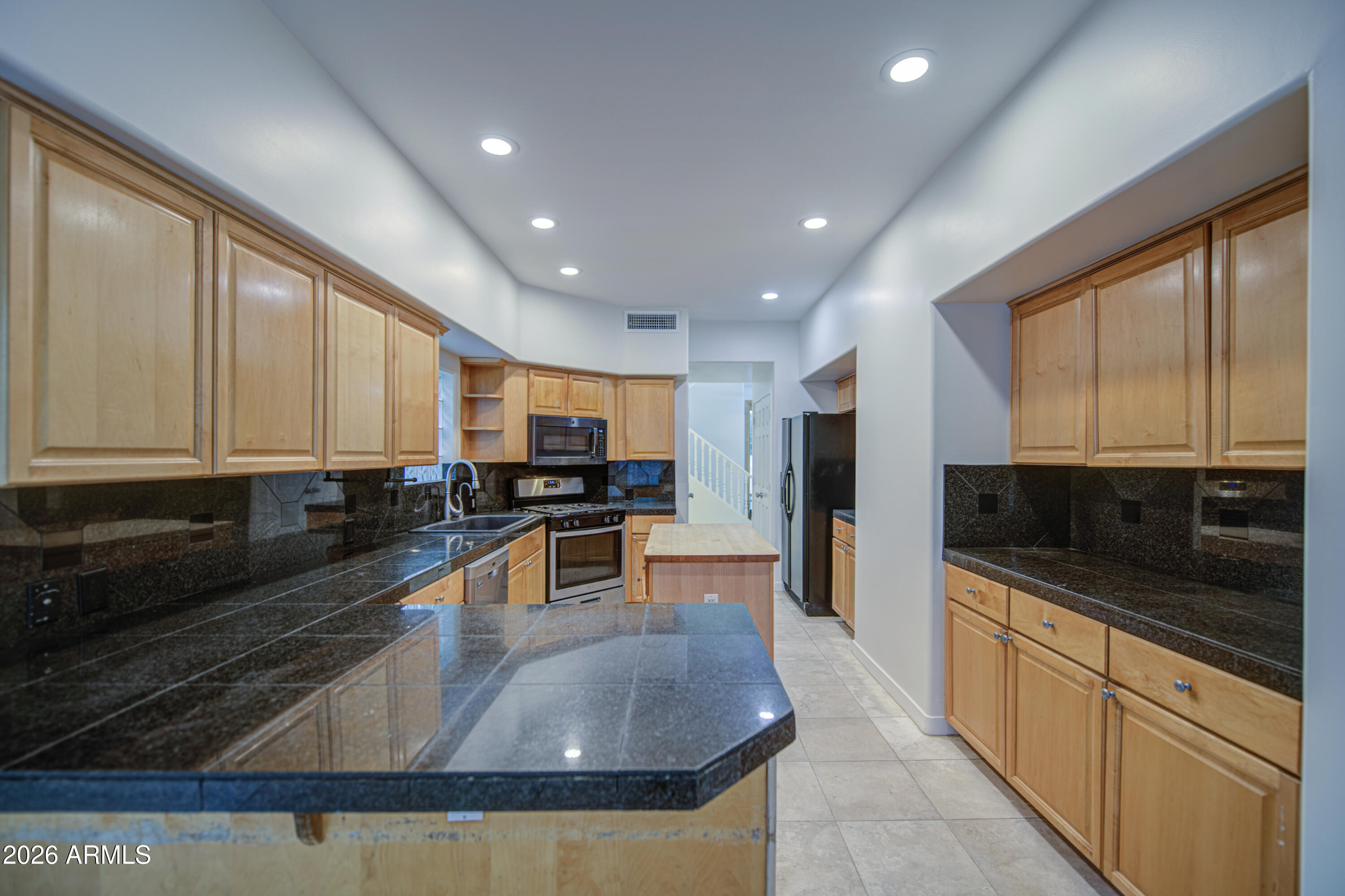 6018 North 5th Place Phoenix, AZ 85014 - Photo 17 of 53 a large kitchen with stainless steel appliances granite countertop a large stove a refrigerator a microwave oven with white cabinets and wooden floor